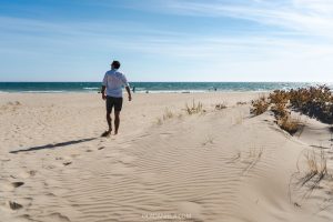 Jorge walking along a long open sandy beach